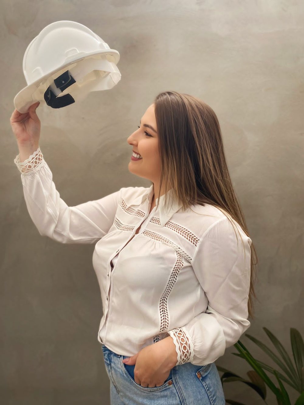 Isabella Fernandes erguendo um capacete de engenharia